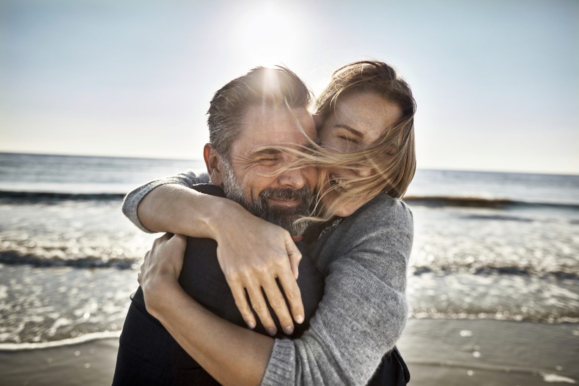 Carefree Mature Man And Woman Hugging At The Sea