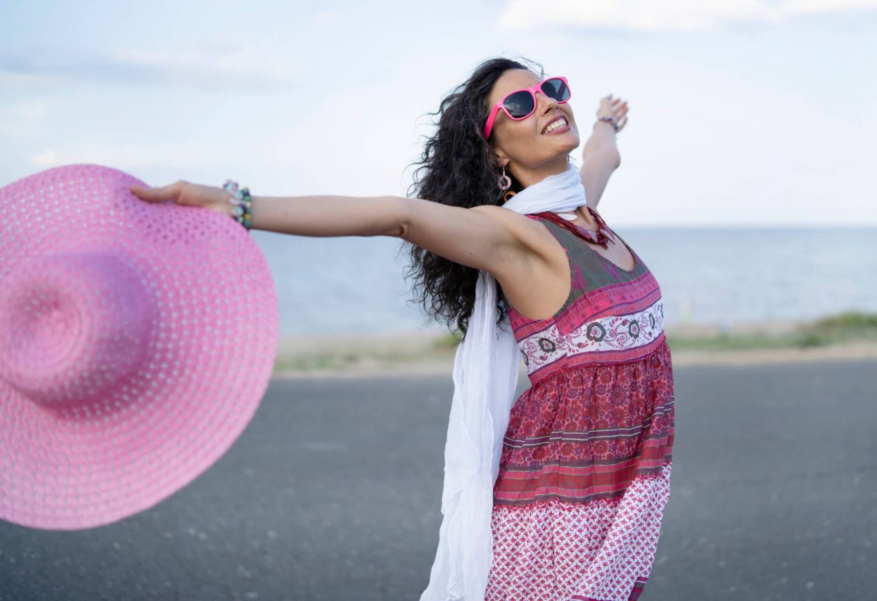 Zomerse Midi Jurken: vrouw met jurk en hoed in haar hand