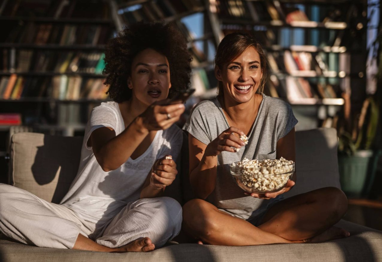 Twee Vrouwen Zitten Op De Bank En Kijken Tiopfilms