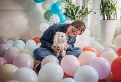 Hondenspullen Dierendag: hond met baasje tussen de ballonnen