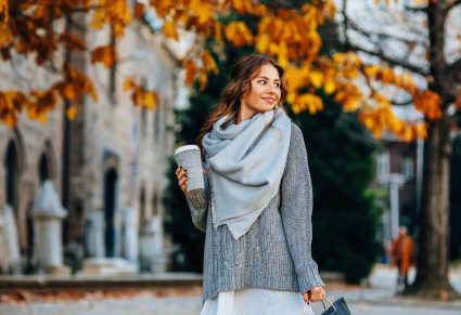 Mooie vrouw op straat met knitwear trui aan