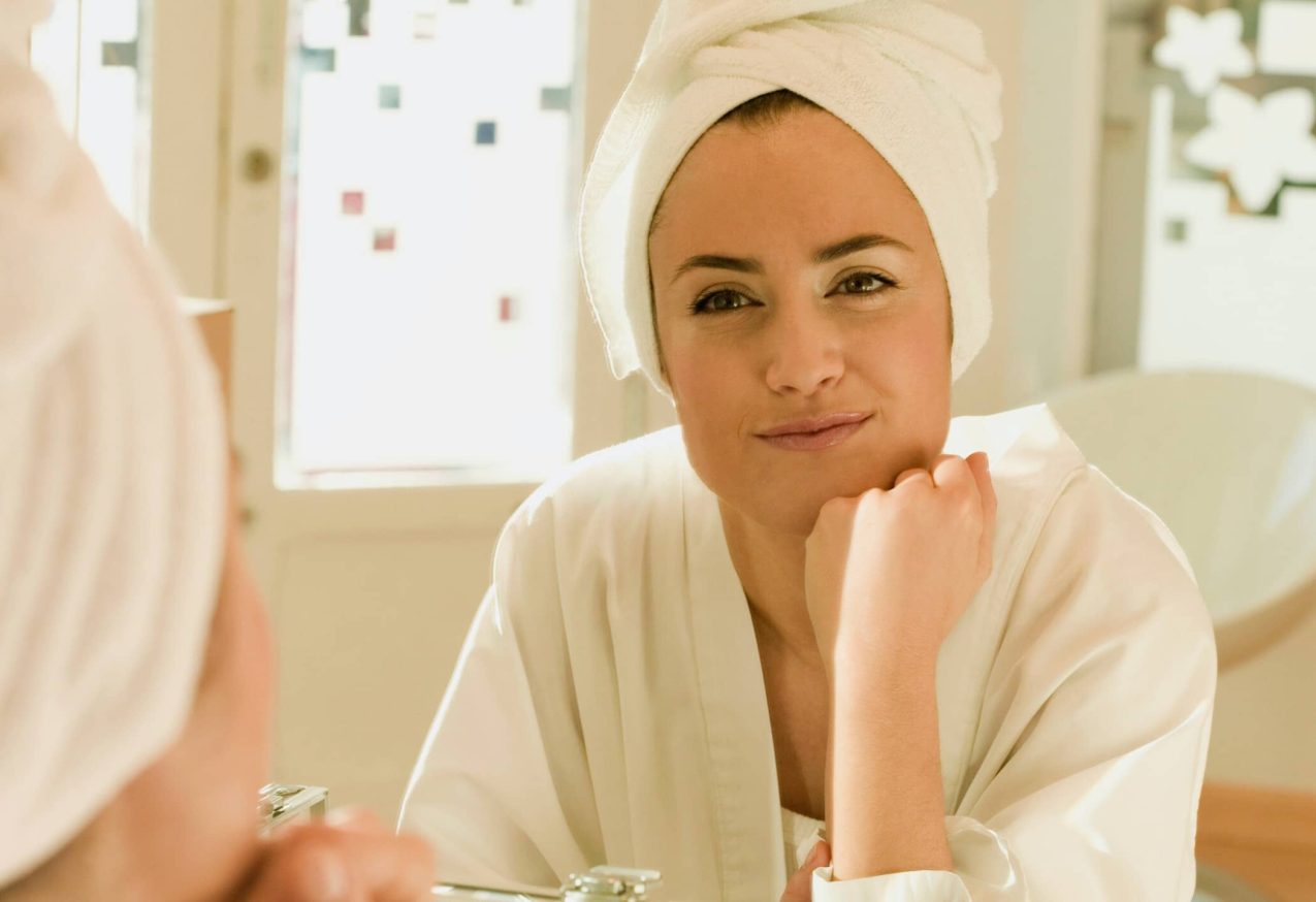 beautytool : Vrouw Kijkt Tevereden In Spiegel Met Handdoek Om Haar Haar