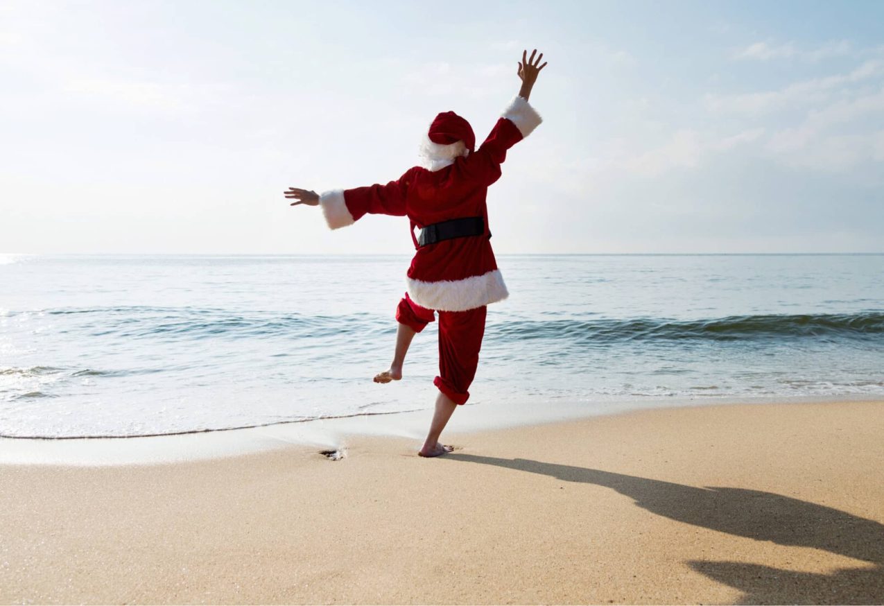 Zonnige Kerstvakantie: kerstman op zonnig strand