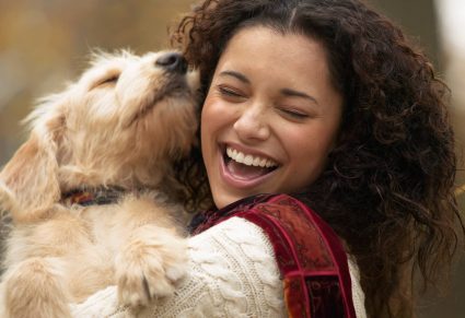 Dagelijkse Routines Hond: Vrolijke vrouw die haar hond knuffelt