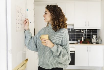 agenda op orde: vrouw vult familieplanner in