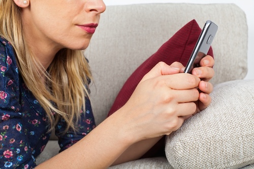 hechte vriendschap: vrouw stuurt appje terwijl ze op de bank ligt