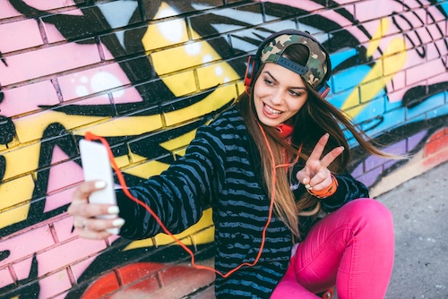 vrouw maakt selfies bij graffiti muur