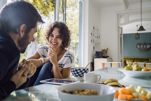 vonk levend in lange relatie: Gelukkige vrouw in gesprek met echtgenoot tijdens het ontbijt