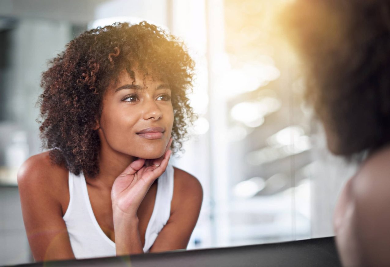 Vrouw Kijkt Tevreden In Spiegel: foundation de hele dag blijft zitten