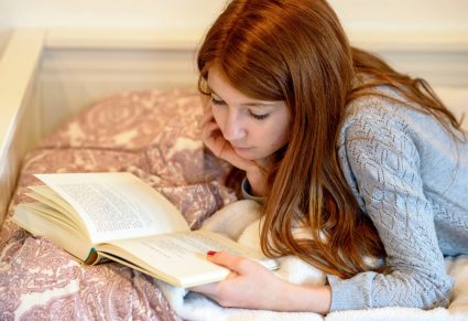 Young Adult Boeken: tiener leest boek op haar bed